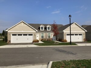 front view of a two unit villa with beige exterior paint and two garages